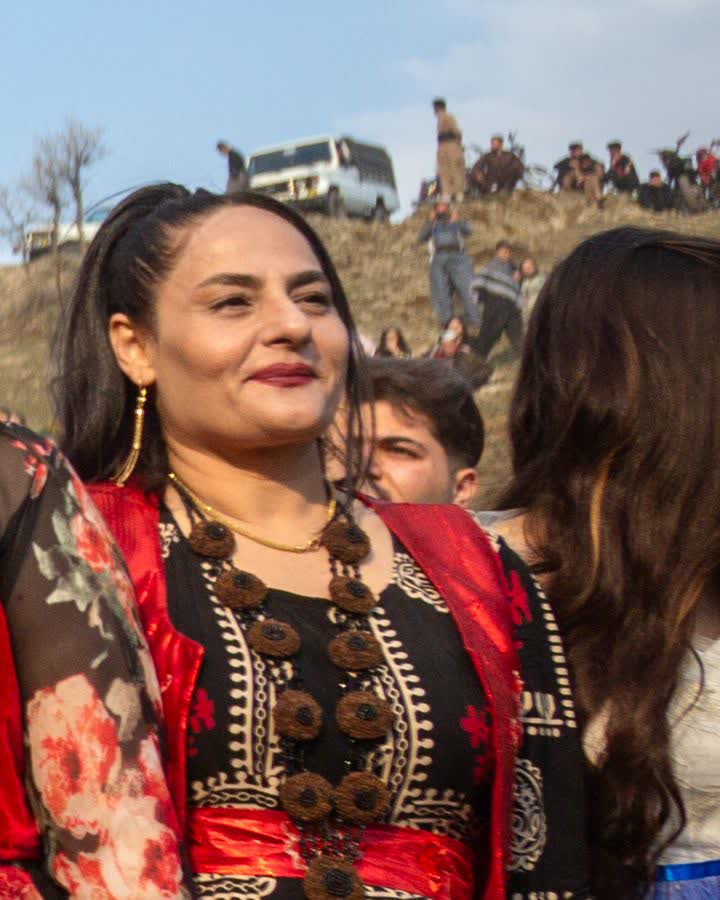 Çiçek desenli siyah kirasfistan ve kırmızı şalıyla kadın