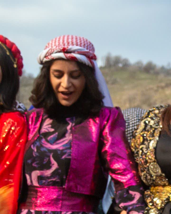 Mor-fuşya desenli kirasfistan giymiş kadın Newroz halayında