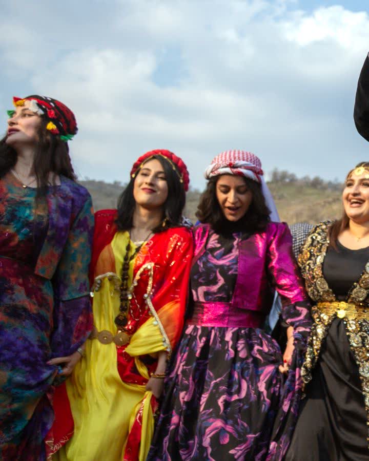 Rengârenk kirasfistanlar giymiş kadınlar el ele Newroz halayında