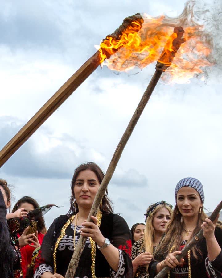 Kırmızı motifli siyah goloni elbiseli kadın Newroz yürüyüşünde